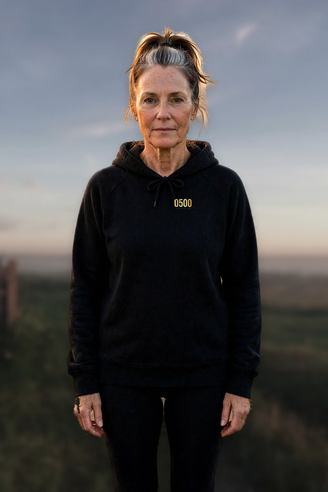 0500DISCIPLINE — Women's Earn the Sunrise Hoodie lead photo on real stock background (2026-10-22)